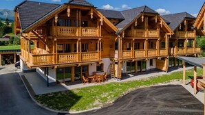 Un chalet en bois doté de balcons, d’une terrasse couverte et offrant une vue sur les montagnes.