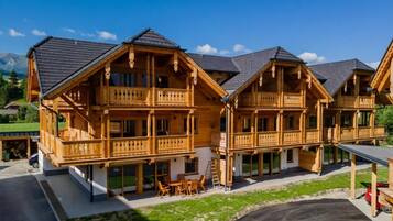 Eine Holzhütte mit Balkonen, einer Veranda und Blick auf die Berge.