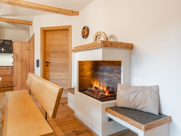 Ein gemütliches Zimmer mit Kamin, Holzmöbeln und einer Tür zu einem weiteren Bereich.