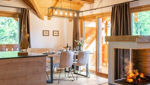 A cozy dining area with a wooden table, chairs, and a fireplace. - Luxuriously furnished penthouse (Mauterndorf)