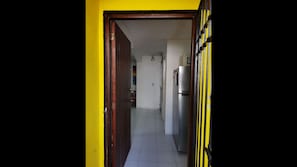 Leading to a fully equipped kitchen area with a refrigerator and sink.