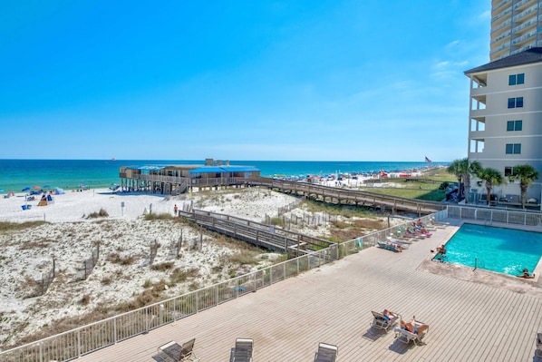 Relax on the beachfront boardwalk with lounge chairs and umbrellas, steps from the ocean and a swimming pool.