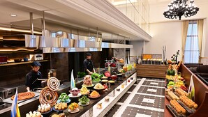 A buffet setup with various food items and a modern kitchen in the background.