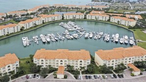 Uma marina com barcos atracados, rodeada por um resort com vários edifícios.