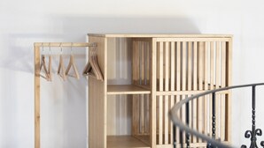 Um guarda-roupa de madeira com várias prateleiras e espaço para pendurar roupas.