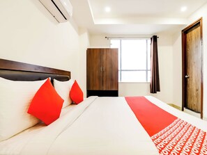 Una habitación de hotel con cama, armario y ventana.