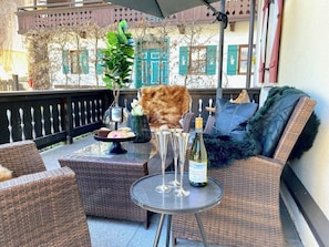 A wicker outdoor seating area with a bottle of wine and glasses on a table. - Belle Kitz urban villa for 11 with sauna & garden (Kitzbühel)