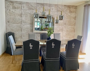 A dining area with a marble wall, a central mirror, and pendant lights. - Stadvilla Belle Kitz (Kitzbühel)