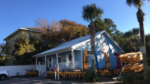 A coastal building with a porch, kayak rentals, and bicycles.