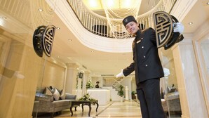 A grand lobby with a curved staircase, a reception desk, and a plush sofa. - Victor Gallery Hotel & Spa (Hanoi)