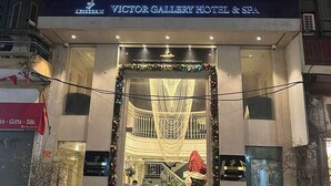 A hotel with a large bow decoration, a sign for Victor Gallery Hotel & Spa, and a Christmas tree. - Victor Gallery Hotel & Spa (Hanoi)