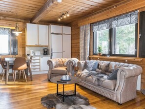 A cozy interior with a sofa, a dining table, and a kitchen area. - Old logger´s house by Interhome (Salla)