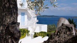 A white building with blue accents, overlooking a coastal view. - Oniro Skiathos (Skiathos)