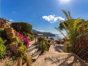 A coastal pathway with steps leading to a scenic view of the sea and a distant island. - Le Paradou by Interhome (Rayol Canadel)