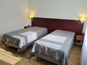 A room with two single beds, wooden headboard, bedside lamps, and a wooden floor. - Charming Renovated House with Private Parking, Garden, and Easy Access to Nancy (Lunéville)