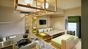 Una habitación de hotel compacta con kitchenette, comedor y zona de estar.