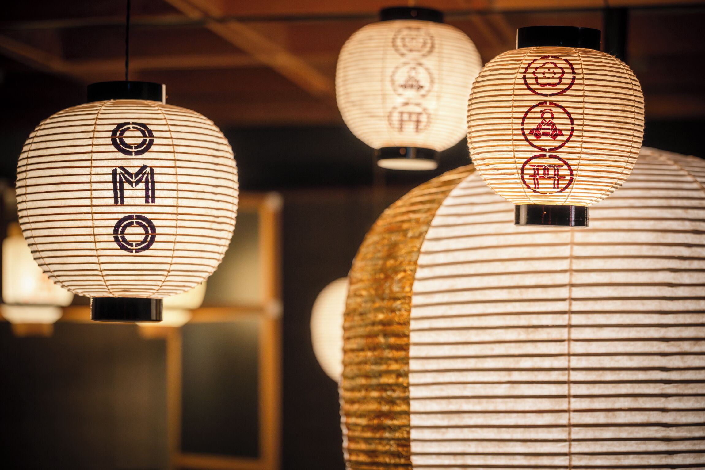 A row of traditional paper lanterns with the characters "OMO" on them.