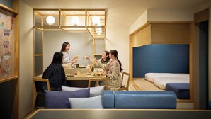 Una habitación con una mesa de comedor, cuatro personas brindando, un sofá y una litera.