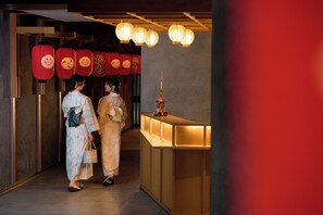 A reception area with a wooden counter and hanging red lanterns.