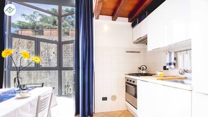 A modern kitchen with white cabinets, a stove, and a dining area with a table and chairs.