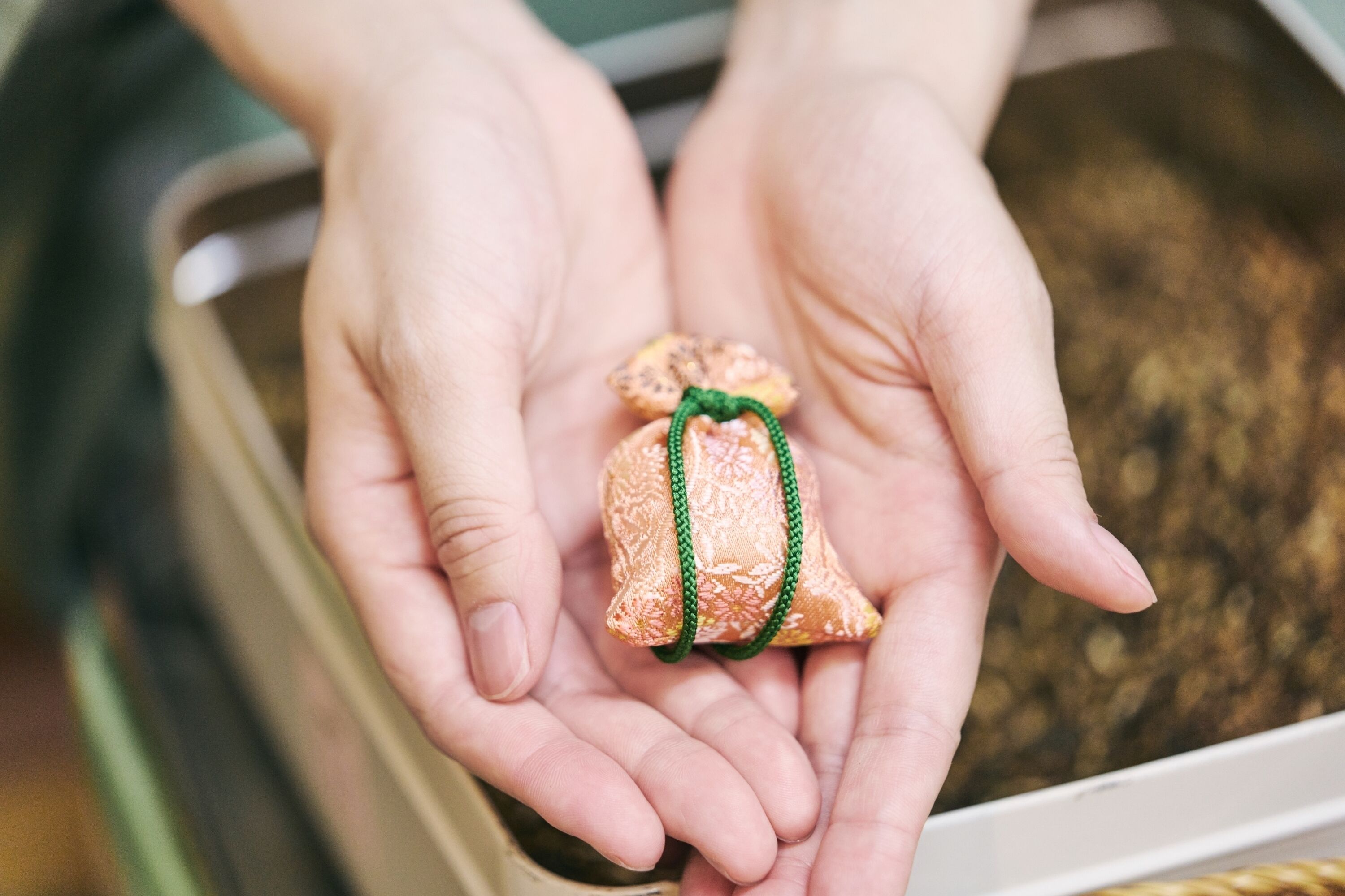 Hands holding a small, wrapped object.