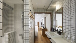A modern bathroom with a shower, a sink with multiple toiletries, and a mirror. - OMO5 Kyoto Sanjo by Hoshino Resorts (Kyoto)