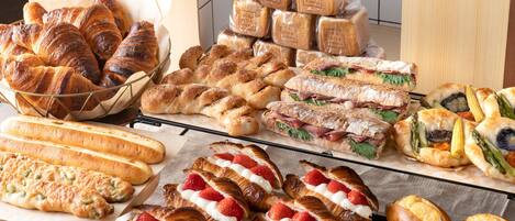 A variety of baked goods including croissants, baguettes, and sandwiches.