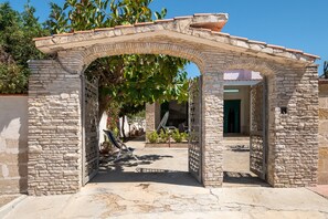 Un arc en pierre mène à une cour intérieure d’où l’on peut admirer un bâtiment.