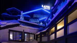 Un espace piscine extérieur chauffé offrant une vue sur l’intérieur de l’hôtel et sur un toit enneigé.