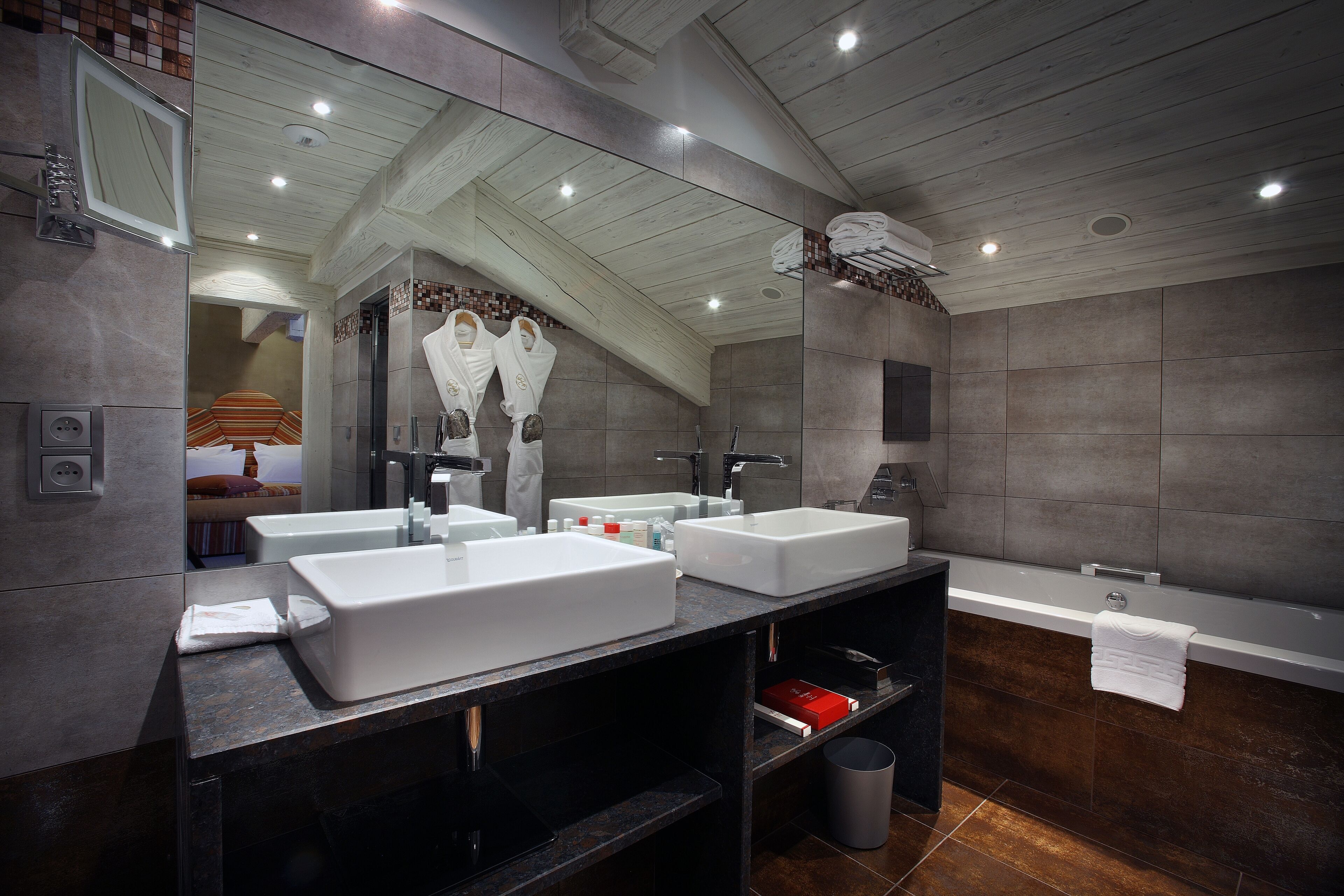 Un baño moderno con dos lavamanos grandes de color blanco, una bañera y un espejo sobre los lavamanos.