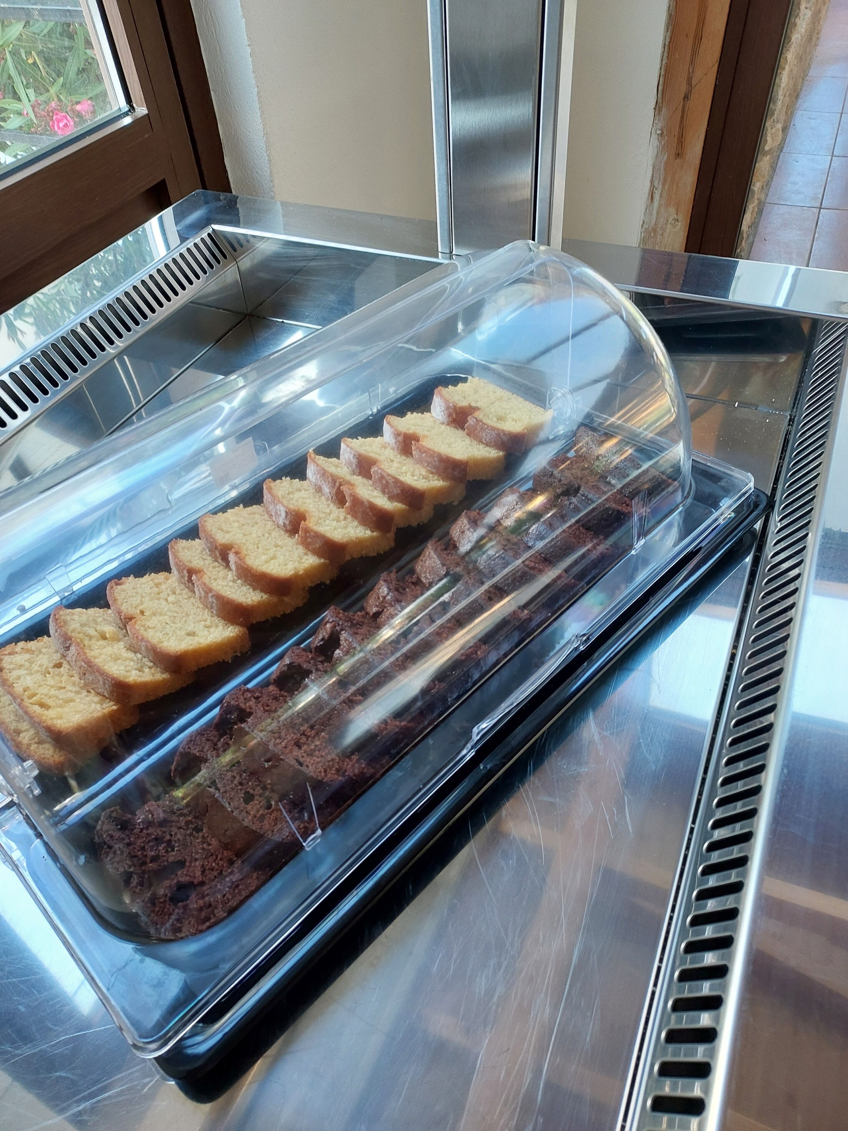 A bakery display case with sliced bread and cake.