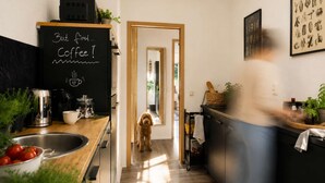Een moderne keuken met een prikbord, een hond en een bewegende persoon.