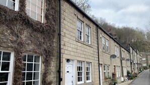 A row of terraced houses with stone walls and white-framed windows. - Meg's Den (Hebden Bridge)