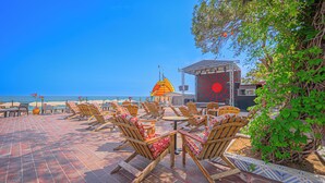 A beachside seating area with lounge chairs and a stage for events. - Rios Beach Hotel (Kemer)