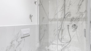 A modern bathroom with a glass shower enclosure, marble tiles, and a control panel. - Italianway - The B Village Superior - 46 (Milan)