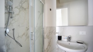 A modern bathroom with a glass shower enclosure, a white sink with a soap dispenser, and a mirror above the sink. - Italianway - The B Village Superior - 50 (Milan)