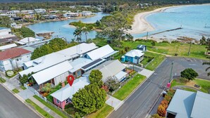 A coastal residential area with modern houses, a beach, and a marina. - Atlantis: retro beachside couples retreat (Currarong)