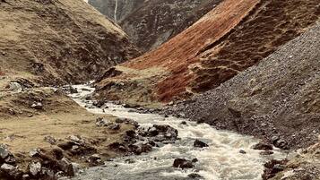 Un río que serpentea a través de un paisaje montañoso con terreno rocoso y vegetación escasa.
