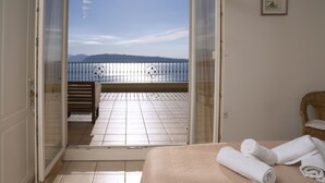 A room with a bed, a balcony with a view of mountains, and a framed picture on the wall. - Bellina Villa, Corfu (Αγνίτσινη)