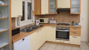 A compact kitchen with a dishwasher, microwave, stove, and cabinets. - Bellina Villa, Corfu (Αγνίτσινη)