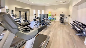 A gym with treadmills, weight machines, and dumbbells. - Modern Twist. Perfect Location. Heated Pool (Orlando)