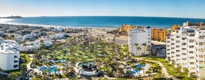 A resort with multiple buildings, a golf course, and a beach.