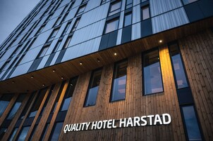 Un edificio moderno con un letrero que dice "QUALITY HOTEL HARSTAD".