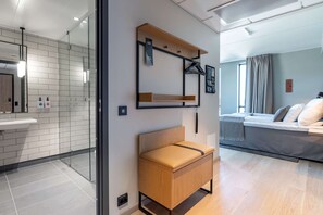 Habitación de hotel moderna con una mampara de vidrio que separa el baño del dormitorio.