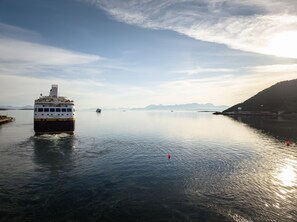 Un ferry llamado "HAVILAND CAPPELLA" en aguas tranquilas, bajo un cielo despejado y con montañas a lo lejos.