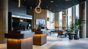 A lobby with a reception desk, seating area, and large windows. - Quality Hotel Harstad (Harstad)