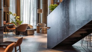 A modern lobby with a large, angular staircase, comfortable seating areas, and large windows allowing natural light. - Quality Hotel Harstad (Harstad)
