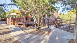 A wooden cabin with a deck, surrounded by trees and a gravel path. - Close to Golf & Hiking: Show Low Family Cabin (Show Low)