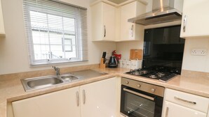 A compact kitchen with a sink, stove, oven, and cabinets. - The Bobbin, Number 11 (Carnforth)