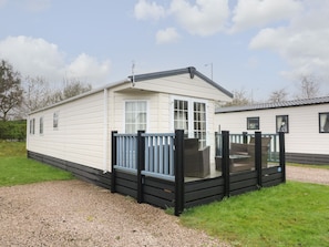 A mobile home with a fenced deck, a window, and a door. - The Bobbin, Number 11 (Carnforth)